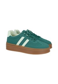 Zapatillas verdes de caña baja con rayas verde claro, talón verde claro y suelas de goma marrón, mostradas una al lado de la otra sobre un fondo blanco.
