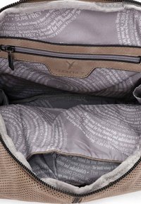 Interno di una borsa in tessuto perforato marrone con fodera grigia, caratterizzato da modelli di testo ripetuti. Include una tasca con zip e rifiniture testurizzate.