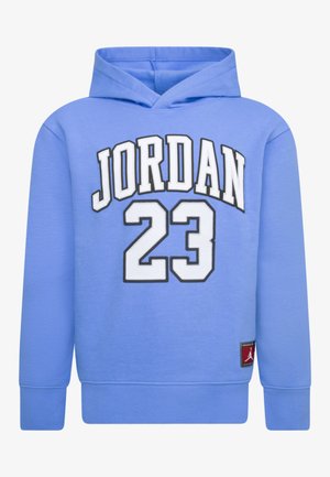 Sudadera azul hecha de tela suave que presenta un gran gráfico de "JORDAN" y el número "23" impreso en blanco con contornos negros. Incluye una etiqueta con el logo.