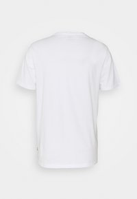 Valkoinen puuvillainen t-paita, jossa on lyhyet hihat, pyöreä kaula-aukko, ommeltu helma ja pieni logo yksityiskohta vasemmassa alareunassa. Sujuva rakenne.