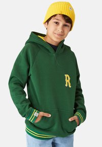 Grön hoodie med gul broderad "R", gul rundhals, ribbade ärmslut med gröna och gula ränder, samt framfickor. Gul mössa.