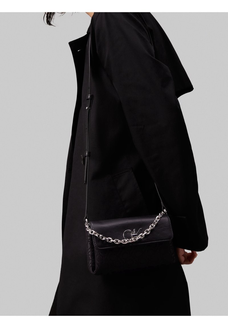 Borsa a tracolla nera con catena, caratterizzata da un motivo strutturato sul davanti e una finitura in pelle liscia, con un dettaglio logo.