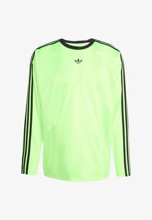 Ilga piedurkne sporta krekls fluorescējoši zaļā krāsā ar melnām svītrām uz piedurknēm un melnu logotipu uz krūtīm. Gluda sintētiska auduma.