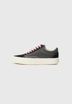 Black canvas and suede sneakers with pink laces, white stitching, and a thick cream-colored rubber sole, featuring a rounded toe design.