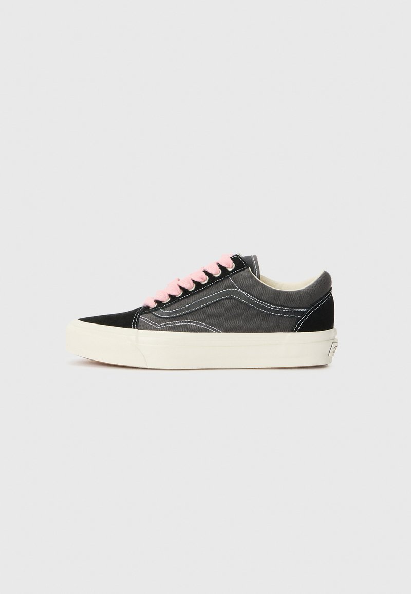 Black canvas and suede sneakers with pink laces, white stitching, and a thick cream-colored rubber sole, featuring a rounded toe design.