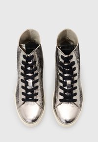 Scarpe da ginnastica alte con una finitura argento metallico, motivo a serpente testurizzato, lacci neri e suola in gomma crema.