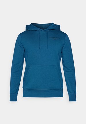 Zila kapuce ar mīkstu audumu. Iekļauj kangaroo kabatu un ribotu aproci. Logo printēts kreisajā krūšu rajonā.