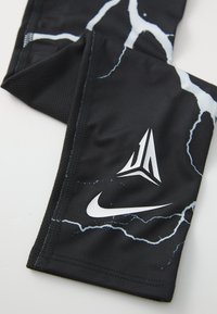 Pantalones cortos deportivos negros hechos de una tela suave con un patrón de rayos en blanco y azul claro. Incluye logotipos en blanco. Panel de malla texturizada incluido.