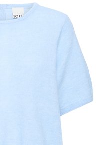 Mīksts gaiši zils īsroku adīts džemperis ar apaļu kakla izgriezumu un ribotām aprocēm, redzama priekšpuses augšdaļa un daļa no labās piedurknes.