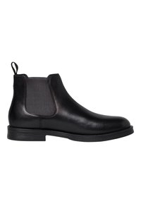 Botín Chelsea de cuero negro con paneles laterales elásticos, punta redonda, tirador y suela de goma texturizada. Acabado suave y diseño elegante.