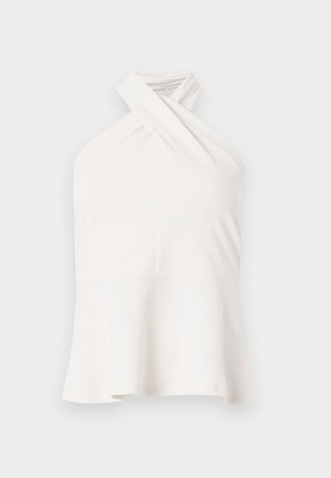 Bílý bezrukávový top s překříženým halterovým výstřihem a rozšířeným lemem, zobrazený na jednoduchém světlém pozadí.