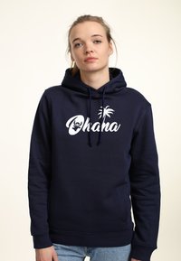 Felpa blu navy realizzata in morbido tessuto con tasca a marsupio, caratterizzata da una stampa bianca "Ohana" e da un design di palma.