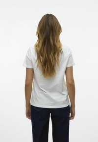 T-shirt en coton blanc à manches courtes, légèrement décontracté, vu de dos. Associe à un jean en denim bleu foncé. Texture lisse.