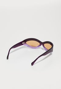 Ochelari de soare purpurii cu formă de pisică, având un design bicolor, lentile de culoare chihlimbar și brațe elegante. Detaliile texturate de pe ramă adaugă interes.