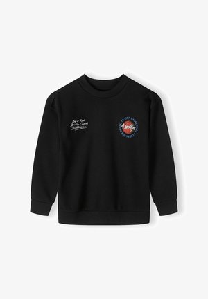 Juodas megztinis ilgomis rankovėmis, su raugtomis rankogaliais ir apvalia kaklo išpjova. Priekyje yra baltas išsiuvinėjimas ir spalvinga krepšinio grafika.