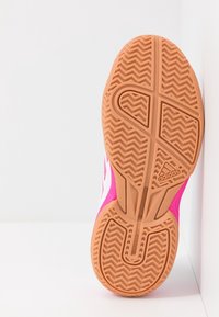 Podešev bot Adidas z texturovanou světle hnědou gumou, s cik-cak vzorem a růžovými akcenty na bocích a horní části.
