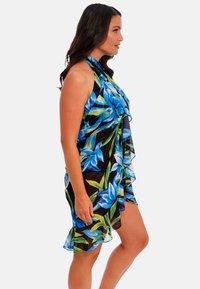 Vestido de cubrimiento de playa floral en negro con patrón de flores azules y verdes, tejido transparente, dobladillo con volantes y diseño de cuello halter.