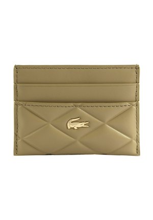 Porte-cartes en cuir beige avec motif matelassé en losanges et logo crocodile doré sur le devant, doté de trois emplacements pour cartes.