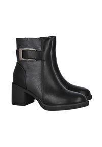 Botas de tobillo negras con tacones de bloque, paneles laterales texturizados y una correa con hebilla de metal sobre un fondo blanco.