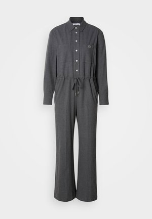 Grå jumpsuit med lange ærmer, knaplukning fortil, snoretræk i taljen og to brystlommer. Fremstillet af et blødt, tekstureret stof.