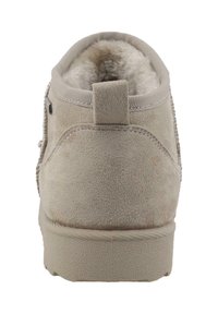 Bottine en suede beige avec une surface texturée, doublure intérieure douce et une languette à l'arrière. Semelle en caoutchouc légère.