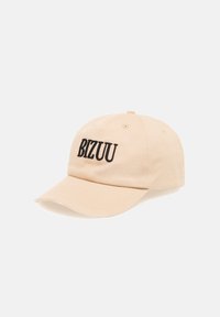 Beige baseballpet met gebogen klep en zwarte geborduurde tekst "BIZUU" aan de voorkant in het midden.