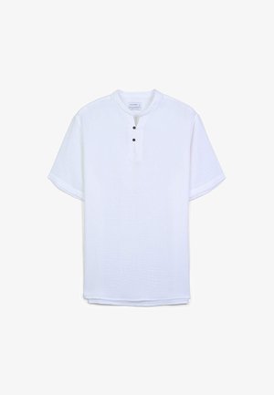 Camicia bianca a maniche corte con tessuto testurizzato, collo henley e tre bottoni marroni. Orlo dritto senza motivi o accenti visibili.