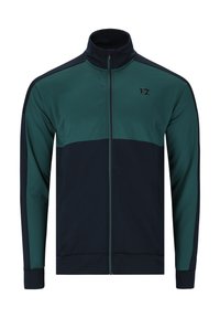 Zipparjacka i mörkgrön och marinblå. Har hög krage, kontrasterande paneler, elastiska ärmslut och en liten logotyp på bröstet.