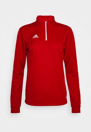 Sudadera deportiva roja con cuello alto, parte delantera con media cremallera, mangas largas y puños acanalados. Presenta el logo blanco de Adidas en la parte superior izquierda.