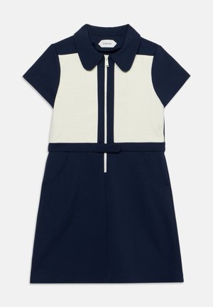 Robe à manches courtes bleu marine et blanche avec col, fermeture éclair devant, ceinture à la taille et poches latérales.
