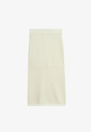 Jupe tricotée couleur crème avec un motif en diamant, taille élastique et texture lisse, s'étendant jusqu'à mi-mollet.
