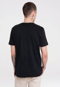 Black cotton t-shirt, short sleeves, classic round neckline, fitted design, smooth texture, and simple styling with no visible logos.