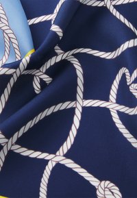 Navy silk scarf featuring a white rope pattern against a smooth, vibrant blue background with yellow accents. Soft, flowing texture.