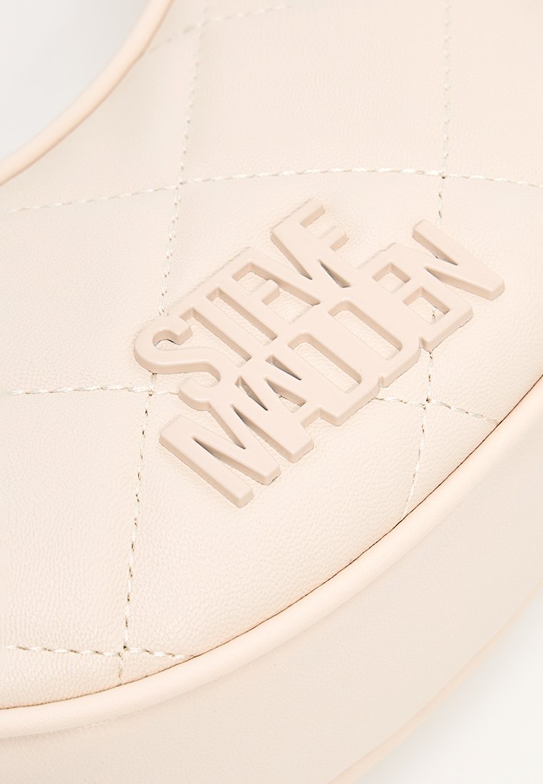 Cremfarbige Kunstledertasche mit gestepptem Muster und dem erhabenen "Steve Madden"-Logo in der Mitte. Glatte Textur und abgerundete Kanten.