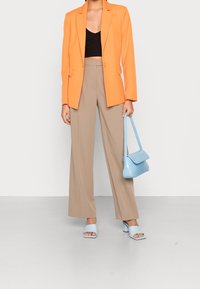 Oranger Blazer, schwarzes Crop-Top, beigeweite Hose, hellblaues Handtasche und passende Absatzsandalen, alles mit glatten Texturen.