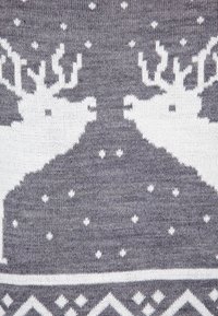 Maglione grigio a maglia con alci bianchi, fiocchi di neve e motivi geometrici sulla parte inferiore, creando un contrasto visivo testurizzato.