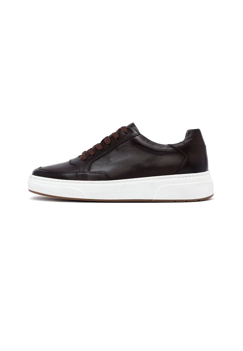 Ciemnobrązowy skórzany sneaker z białą gumową podeszwą, zaokrąglonym noskiem i kontrastującymi brązowymi sznurówkami. Charakteryzuje się gładką fakturą i minimalistycznym designem.