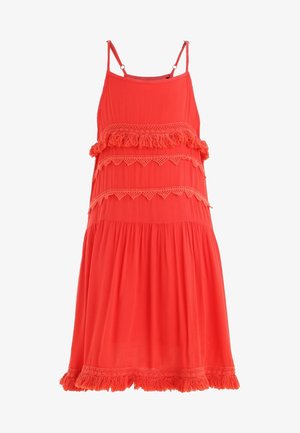 Heldere koraalkleurige jurk met dunne bandjes, voorzien van gelaagde ruches, kantaccenten en een geplooide onderrand. Lichtgewicht stof, ontspannen pasvorm.