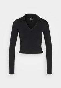 Svart långärmad crop top med V-halsringning och krage. Tillverkad av ett slätt, stretchigt material. Har en figurnära design och minimalistisk stil.