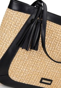 Borsa a spalla in paglia naturale con dettagli in pelle nera, presenta un grande particolare con nappina, superficie testurizzata e un'etichetta del marchio in evidenza.