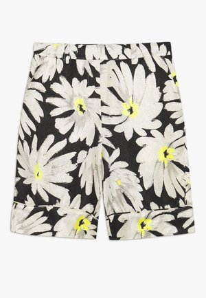 Zwarte shorts met grote witte en gele madeliefjesprint en omgeslagen zomen, plat weergegeven op een witte achtergrond.
