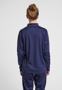 Maglietta a maniche lunghe blu navy realizzata in tessuto testurizzato con colletto, caratterizzata da una vestibilità comoda e polsini elasticizzati.