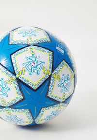 Minge de fotbal albastră și albă, cu panouri în formă de stea decorate cu motive de păianjen, suprafață texturată și cusături consolidate. Vizibilă eticheta de calitate FIFA.