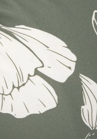 Grüner Stoff mit großen weißen Blumenmustern, detaillierten Konturen und weicher Textur, die ein von der Natur inspiriertes Design schaffen.