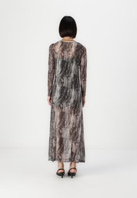 Dolga, prosojna obleka z vzorcem kače v odtenkih črne, sive in rjave. Ima dolge rokave in padajočo silhueto.