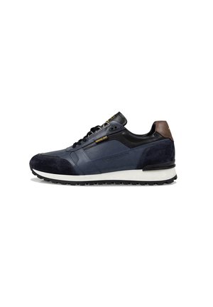 Basket en bleu marine avec lacets noirs, onglet de talon marron, semelle blanche et semelle noire, montrant le profil latéral sur un fond blanc.