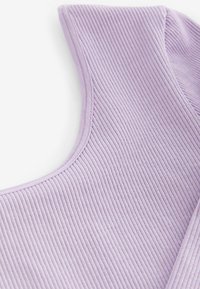 Ribbed lila kangas, jossa on tyylikäs kaula-aukko ja sileä reunus, korostaa pehmeää pinta-alaa ja kevyttä, ilmavaa ilmettä.