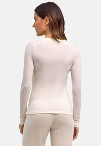 Lekka, kremowa bluzka z długim rękawem o dopasowanym kroju, z okrągłym dekoltem i minimalistycznym designem; gładka faktura z subtelnymi detalami przeszyć.