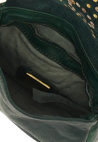 Interno di una borsa in suede verde con una texture liscia, dettagli dorati e più tasche caratterizzate da un rivestimento a righe sottili.