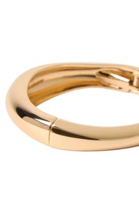 Goldfarbener, kreisförmiger Armreif mit glatter, glänzender Oberfläche und nahtlosem Design, das ein kleines Verschlussdetail an der Verbindung aufweist.